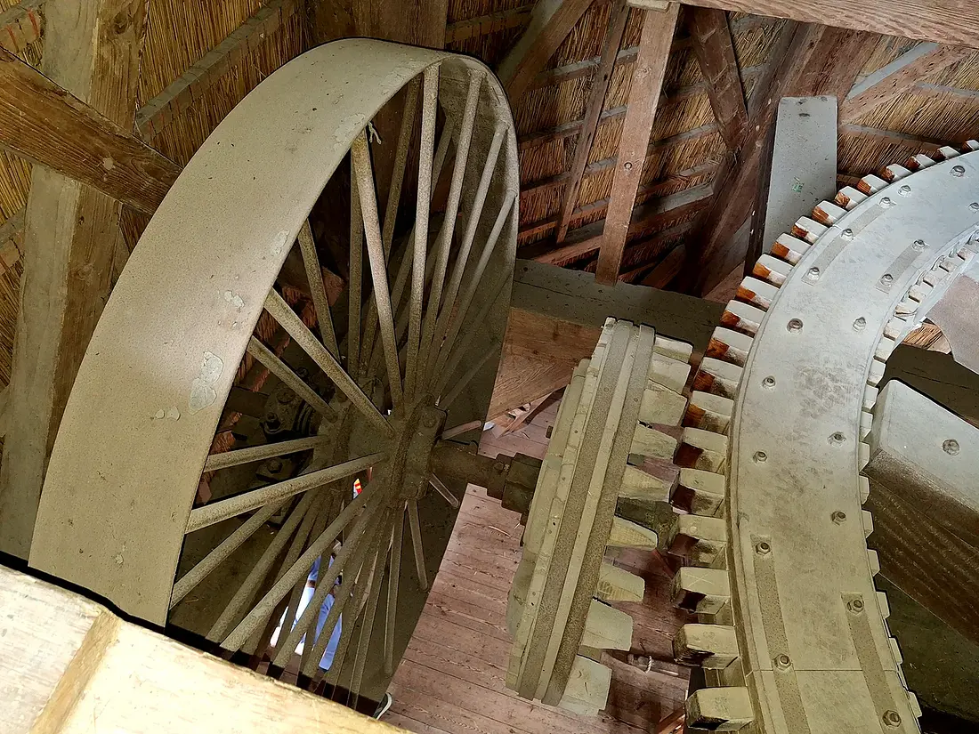 15, Molen 01241 De Duif (Nunspeet), Jay Verkerk (16-07-2024)&nbsp;Het vliegwiel dat vroeger met een leren riem werd aangedreven door een elektromotor. Hiermee kon je het gaande werk laten lopen als er geen of niet voldoende wind was. De elektromotor bevindt zich nog steeds in de molen. | Database Nederlandse molens