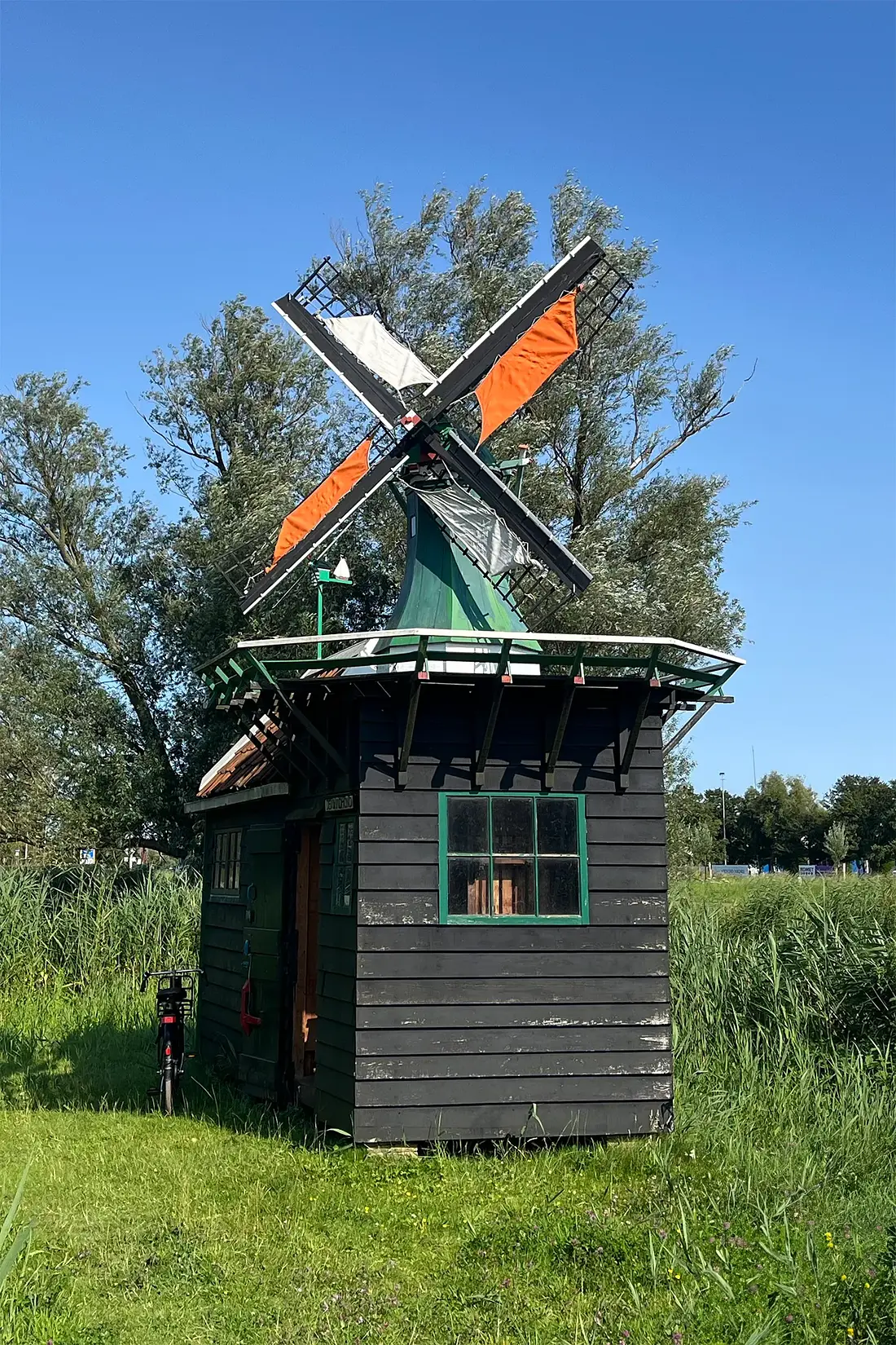 Molen 10256 De Windhond (Zaandam), Job de Groen (24-07-2024)&nbsp;Molen de Windhond draaiend met “4 in de laagst” met de oranje-witte Zaanse zomerzeilen. | Database Nederlandse molens