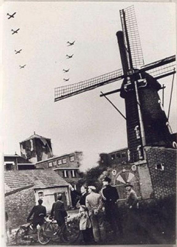 2, Molen 02504 Molen Kuyken (Bergeijk), Foto: collectie Menno van Putten, tijdens de Operatie Market Garden&nbsp;17-09-1944 - Dakota's vliegen over de bergkorenmolen 'Kuyken' in Bergeijk op 17 september 1944. De militaire operatie Market Garden eindigde in een catastrofe.Het plan was simpel: werp parachutisten af diep in vijandelijk gebied en laat ze daar bruggen en steden veroveren waarna de grondtroepen door de Duitse verdediging breken en naar Arnhem rijden. Als de troepen tot in Arnhem waren opgerukt, lag de route naar het Duitse Ruhrgebied en Berlijn open, en zou Duitsland nog voor Kerstmis 1944 zijn verslagen. Helaas mislukte de operatie en duurde de oorlog nog een halfjaar langer. info: www.nu.nl | Database Nederlandse molens