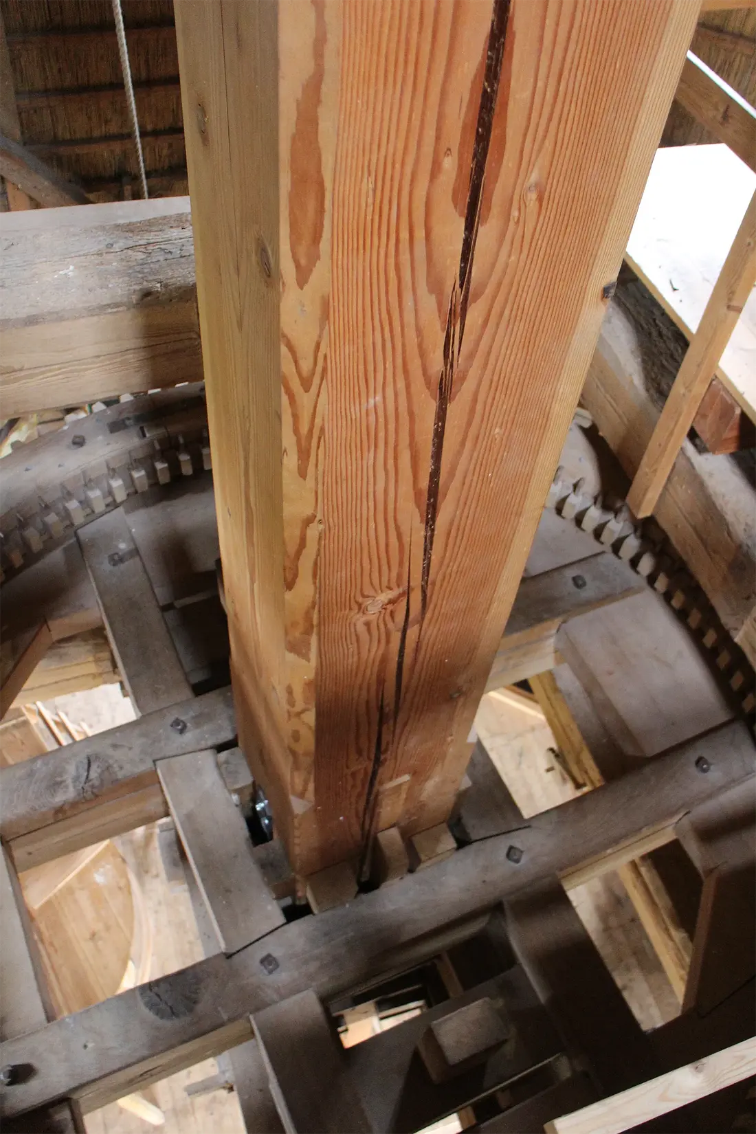 18, Molen 01245 De Hoop (Oldebroek), Gijs van Reeuwijk (21-06-2024)&nbsp;Bovenzijde van het spoorwiel. Tussen plooien en kruiarmen de houten "sleutel" waarmee de onderste koningspil voor het oliewerk in zijn werk kan worden gezet. | Database Nederlandse molens