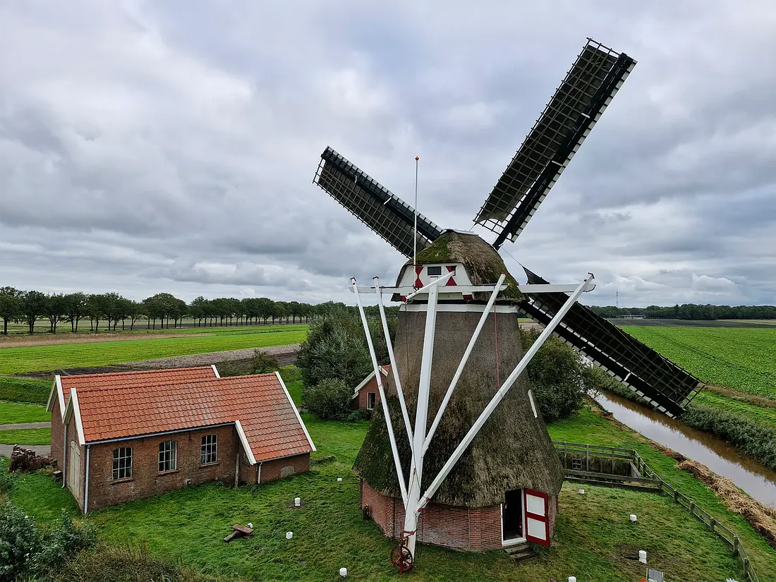 3, Molen 00547 Molen van de Groote Polder (Slochteren), Rob Hoving (01-10-2024)&nbsp;De molen in de zeilen. Links is het voormalig gemaal te zien, die samen met de molen de Groote Polder bemaalde. Op de achtergrond de molenaarswoning. | Database Nederlandse molens