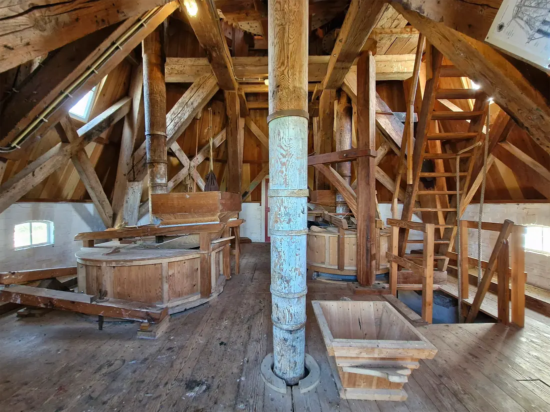 14, Molen 00551 De Noordstar (Noordbroek), Rob Hoving (22-10-2024)&nbsp;Overzicht op de stellingzolder met twee koppels maalstenen. Op de voorgrond de pelsteen. | Database Nederlandse molens