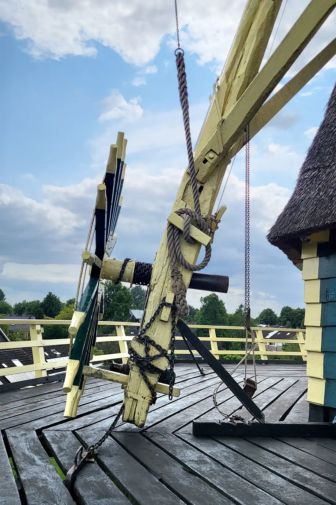 10, Molen 00913 Nooit Gedacht (Warnsveld), Jorben Harbers (06-08-2025)&nbsp;Staart met kruiwiel waar een vangtouw aan vastgemaakt is. Aan de ketting voor de bediening van de Ten Have kleppen zit een gewicht. Daar komt meer druk op als de kleppen open gaan, en de bazaanstok met ketting omhoog gaat.&nbsp; | Database Nederlandse molens