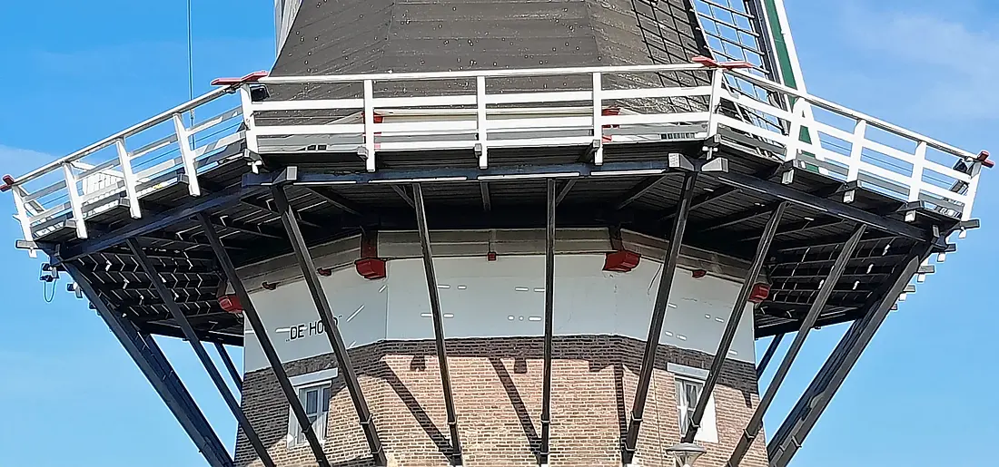 5, Molen 02715 De Hoop (Almelo), Martin E. van Doornik (03-05-2025)&nbsp;Het is duidelijk te zien dat het Friese achtkant wat te breed is uitgevallen voor de stenen onderbouw. Het witte gedeelte is verticaal opgemetseld en de achtkantstijlen rusten op de rode balken. | Database Nederlandse molens