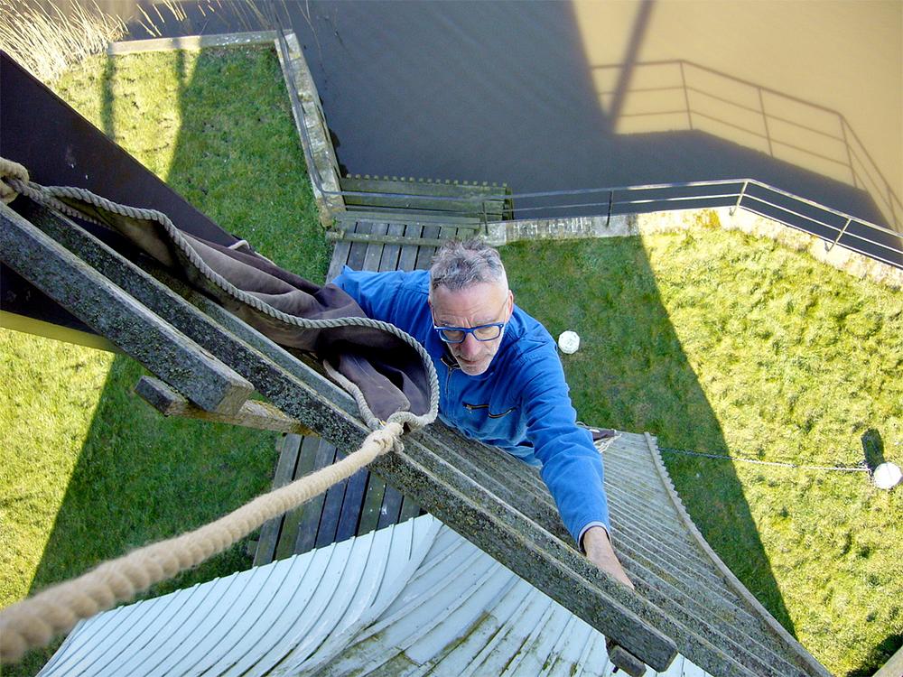 6, Molen 03050 De Olifant (Birdaard / Burdaard), Wim Rietdijk (17-3-2016). Het voorleggen van een zeil door de molenaar. | Database Nederlandse molens