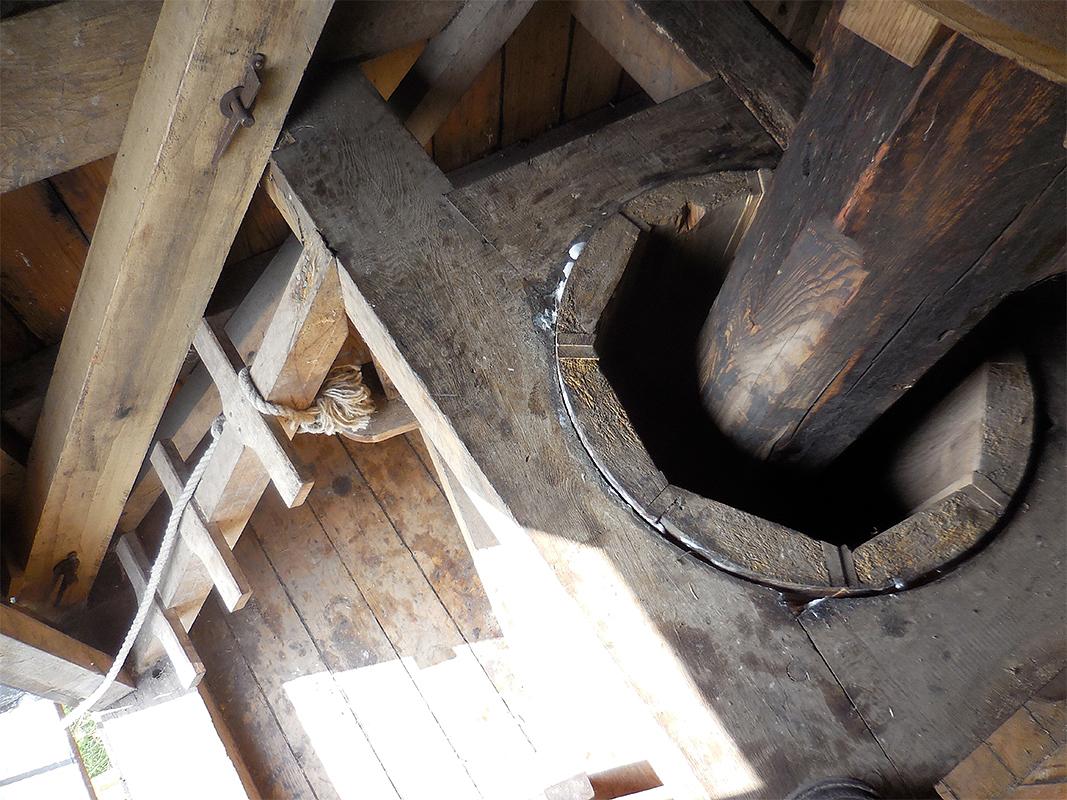15, Molen 06486 Jansmole (Goëngahuizen/ Goaiïngahuzen), Anon. (zomer 2017)De spil komt boven in de kast uit de koker. De steenburrie draait om de koker die een geheel is met de toren. Wat een beetje verwarrend kan zijn, is dat men de toren in Friesland “It hûs” - het huis - noemt en het huis de kop. Dat is vermoedelijk de reden dat men in de molenaars cursus voor de kokermolen de overbodige toevoeging onder(toren) en boven(huis) heeft gebruikt en die benamingen bij de spinnekop in de tekst heeft aangehouden. | Database Nederlandse molens