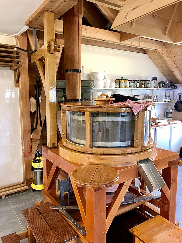 16, Molen 10251 De Verwachting (Hollum (Ameland)), Sander Boom (1-8-2020)De steen wordt aangedreven door de spil op de achtergrond, welke op eenzelfde manier wordt aangedreven als de zagerij van De Zwaluw te Birdaard. | Database Nederlandse molens