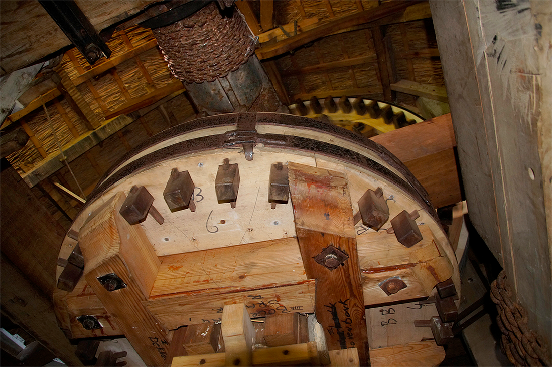 12, Molen 06432 Het Zwaantje / Huitebuurstermolen (Nijemardum / Nijemirdum), Matthieu Hoogduin (22-4-2017)Foto uit de kap van de molen. Blik op de bovenbonkelaar. Er is nog een stuk van het bovenwiel te zien alsmede de met een ketting verzwaarde as. | Database Nederlandse molens