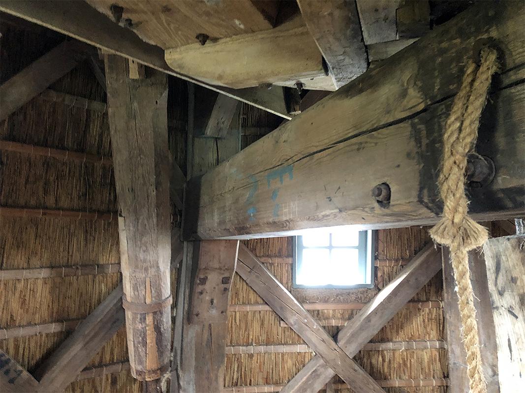 17, Molen 00689 (Naamloos) (Makkum), Sander Boom (10-4-2021)Toelichting fotograaf: Uniek in het noorden: de donsbalk hangt tussen 2 achtkantstijlen. In het noorden is het gebruikelijk dat de donsbalk op de legeringsbalken ligt. Ook is de steenspil van het voormalige tweede koppel stenen te zien. Op de locatie van dit voormalige tweede koppel is te zien dat de vloer nieuwer is, en op de begane grond zijn nog sporen te zien van het bijbehorende paard. Ik vraag me nog steeds af, waarom de steenspil er nog is!  | Database Nederlandse molens