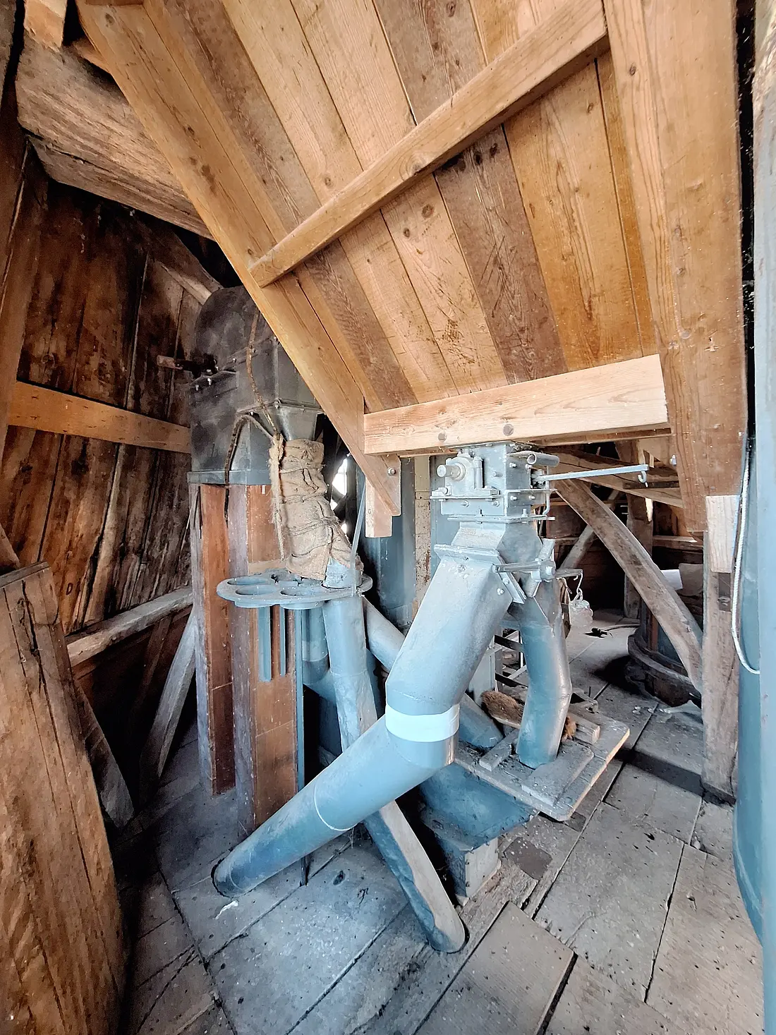 29, Molen 03114 Teunismolen (Dinxperlo - De Heurne), Jay Verkerk (25-04-2026)&nbsp;Links de eerste (dus laagste) elevator, deze heeft verschillende uitgangen zoals onder andere de houten mengketel en de tweede (dus hoogste) elevator. Rechts boven zit een silo, deze heeft twee uitgangen: het kan in de tweede (dus hoogste) elevator gestort worden en er is een uitgang (niet meer bruikbaar) die halverwege de maalzolder stopt. | Database Nederlandse molens