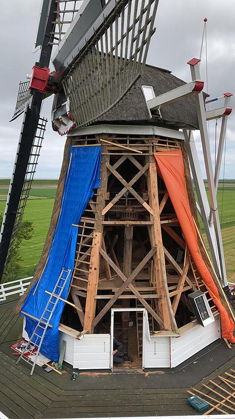 6, Molen 03226 De Hond (Paesens / Paezens), Rolf Dijkema van ‘De Molenmakers’ (5-6-2019)Twee van de achtkant stijlen zijn gerenoveerd met respectievelijk 7 en 4 meter nieuw hout. De veldkruisen zijn vervolgens weer terug geplaatst. Aan 3 zijden wordt nieuw riet aangebracht en ook het riet van de kap wordt vervangen. | Database Nederlandse molens