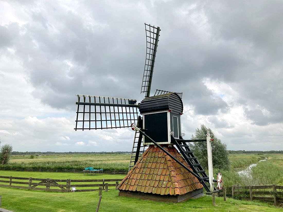 1, Molen 10043 De Ikkers (Wartena / Warten), Job de Groen (18-8-2021)Molen De Ikkers vanaf het water genomen, molen lijkt al geruime tijd stil te hebben gestaan. | Database Nederlandse molens