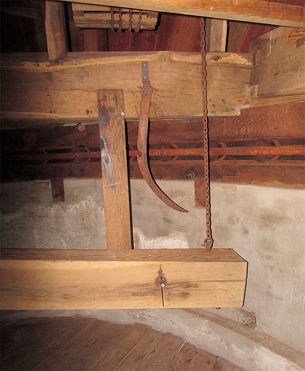 11, Molen 00878 De Engel (Varsseveld), Piet Glasbergen (15-10-16)De trommelvang: balk (zo lang en zwaar dat hij geen extra contragewicht heeft), sabelijzer, trommel nb. onderin de muur een gat (met klep). Deze gaten zitten rondom de kap; ze zijn bedoeld voor balken om een buitensteiger aan te bevestigen. Sinds de opkomst van de hoogwerkers niet meer in gebruik. | Database Nederlandse molens
