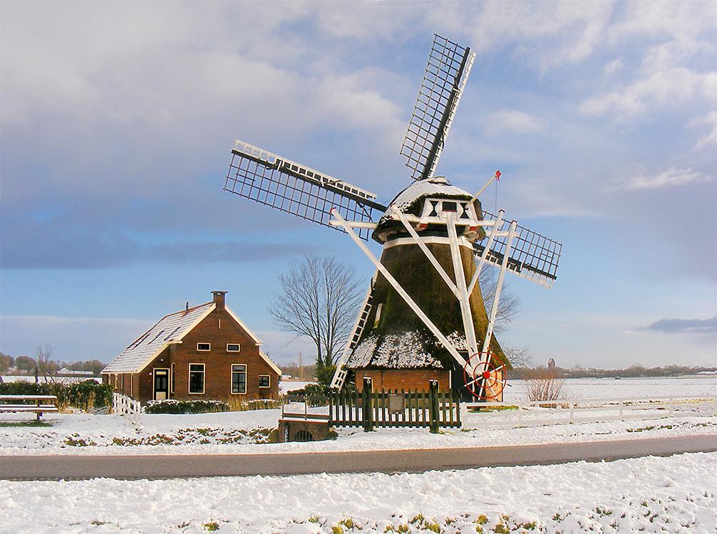 4, Molen 00545 Fraeylemamolen (Slochteren), Vanuit de andere richtingen staat de molen wel vrij. In de verte de zadeldakkerktoren van Slochteren. In de rouwstand vanwege het overlijden van Jan Heijdra.Martin E. van Doornik (16-1-2016) | Database Nederlandse molens