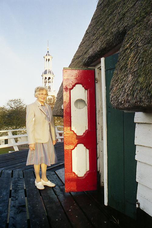 8, Molen 06416 Ceres (Spijk), Martin E. van Doornik (oktober 1984)De fraaie stellingdeuren zijn afkomstig uit een roef van een zeilschip. Links de echtgenote van toenmalig molenaar Keizer.  | Database Nederlandse molens