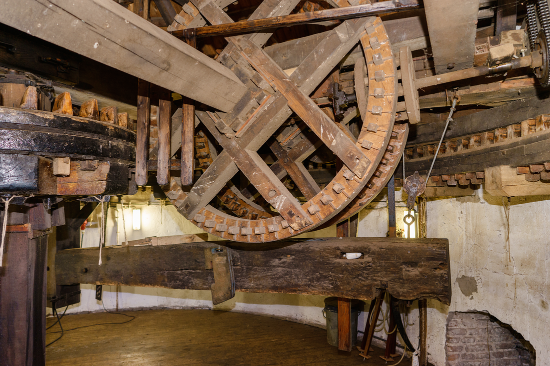 14, Molen 00862 Buitenmolen (Zevenaar), Marcel van Nies (13-01-2018)De elektrische aandrijving van het kruiwerk loopt via de ketting in de rechterbovenhoek van de foto. De twee grote verticale kammenwielen draaien tijdens het kruien in tegengestelde richting, en drijven elk aan een zijde in de kap een rondsel aan. | Database Nederlandse molens