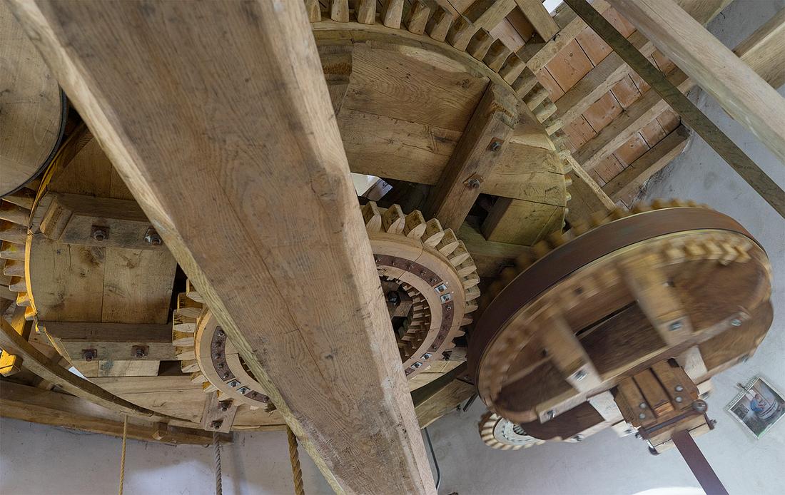 9, Molen 02781 Windlust (Nederweert-Roeven), Marcel van Nies (25-4-2018)Het grote spoorwiel drijft het steenrondsel linksboven in beeld aan. Onder het spoorwiel is een kleiner oliespoorwiel geplaatst. Het achterste tandwiel wordt rechtstreeks door een elektromotor aangedreven. Het rechter wiel drijft de oliemolen aan, en dat kan dus naar keuze op wind of elektrisch. Op de foto is de aandrijving elektrisch. | Database Nederlandse molens