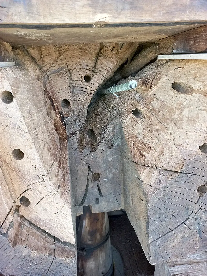 13, Molen 12350 Aurora (Baexem), Frans Verstappen (18-6-2023)De kopse kant van de steenbalk. Je ziet de geboorde gaten waarin later de staven ingestoken worden. De sparing van de enkele spoorstijl is duidelijk te zien.  | Database Nederlandse molens