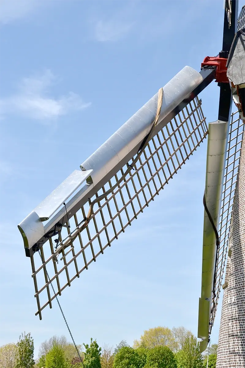 7, Molen 02844 (Naamloos) (Hapert), Rob Pols (3-5-2023)Detail van het wieksysteem Van Bussel met remklep. Opvallend: de zeilklampen zijn op het hekwerk van de wieken bevestigd. | Database Nederlandse molens