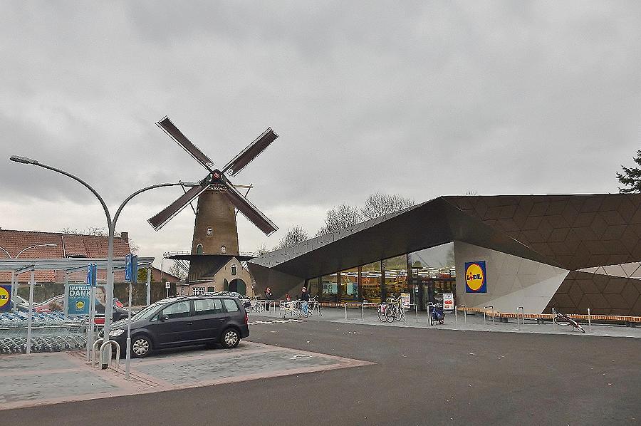 1, Molen 00370 Koningin Wilhelmina (Dongen), De oude kledingwinkel van Piet Kerkhof is in 2014 gesloopt en op de plaats daarvan is datzelfde jaar een LIDL supermarkt in futuristische bouwstijl herrezen.  Tony Hop (14-2-2015).  | Database Nederlandse molens