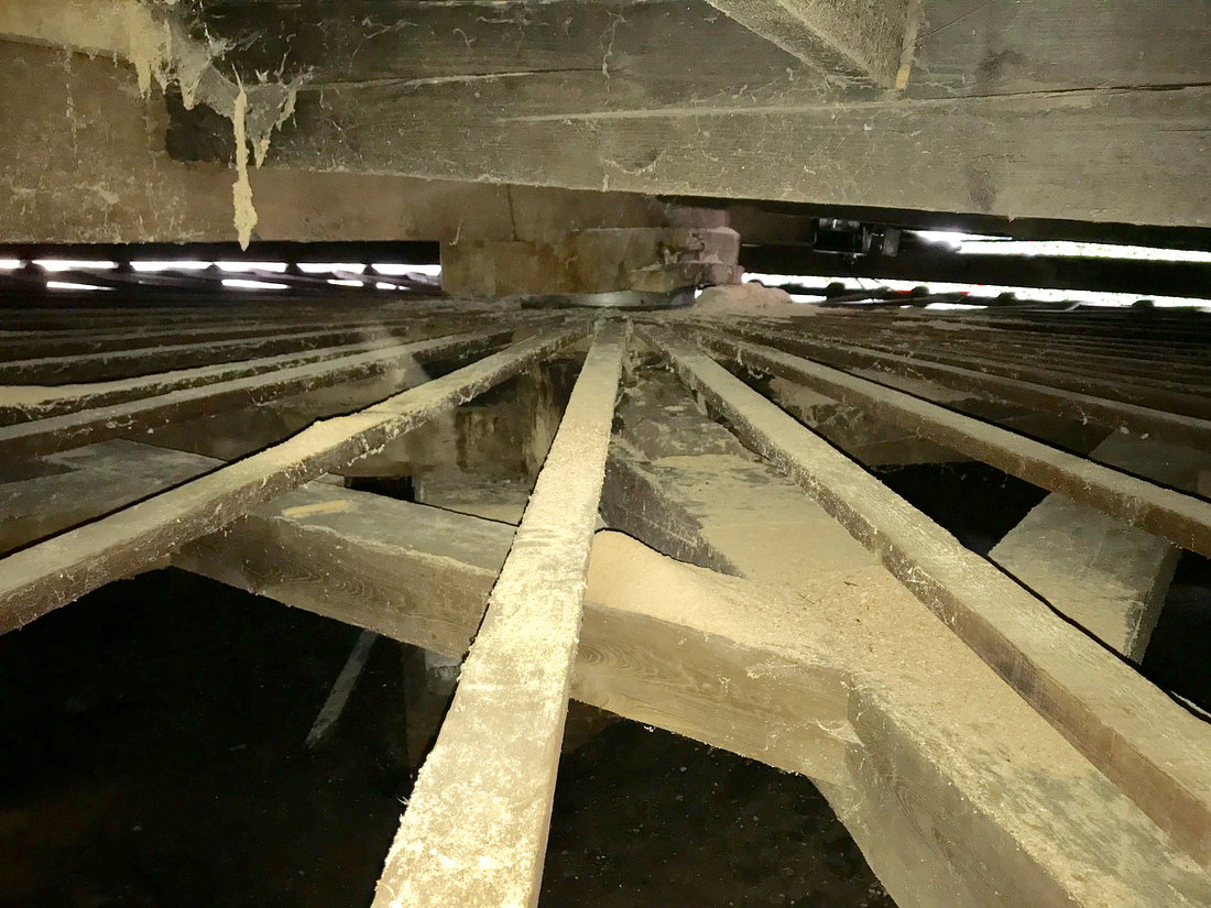 12, Molen 02571 De Eenhoorn (Haarlem), Toby de Kok (25-11-2017)Een kijkje vanaf achter de rollen. We zien kruisbalken, zwaarden, een deel van een van de steunbalken, de sleutelbalk en de koning. | Database Nederlandse molens