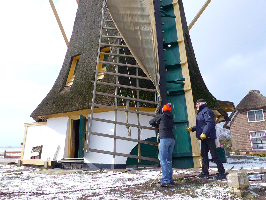 5, Molen 00815 Meermolen / De Onrust (Muiderberg), Piet Glasbergen (28-2-2018)MIO Stella Jurgens krijgt les van Thon Stoffelen. Het voorleggen van zeil met een zwicht (lange halve). | Database Nederlandse molens