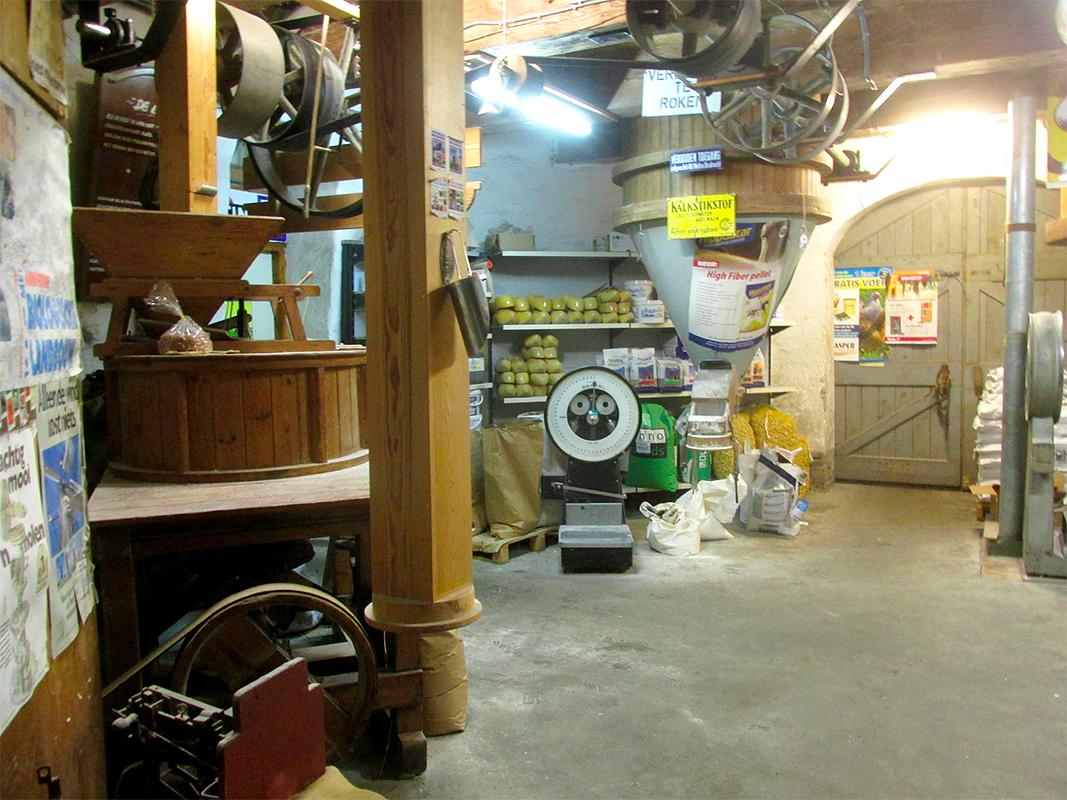 10, Molen 02634 De Lelie (Ommen), Piet Glasbergen (15-12-2017)Begane grond met veel bedrijvigheid: uiteenlopende produkten, motorgedreven kleine maaltrommel, grote mengtrommel. | Database Nederlandse molens