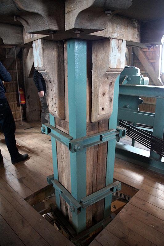 12, Molen 01146 De Kraai (Westbroek), Matthieu Hoogduin (13-4-2019)De koningsspil is met staal versterkt vanwege de krachten die daar op kwamen in de tijd van de elektriciteitsopwekking. Op de achtergrond de nog aanwezige generator. | Database Nederlandse molens
