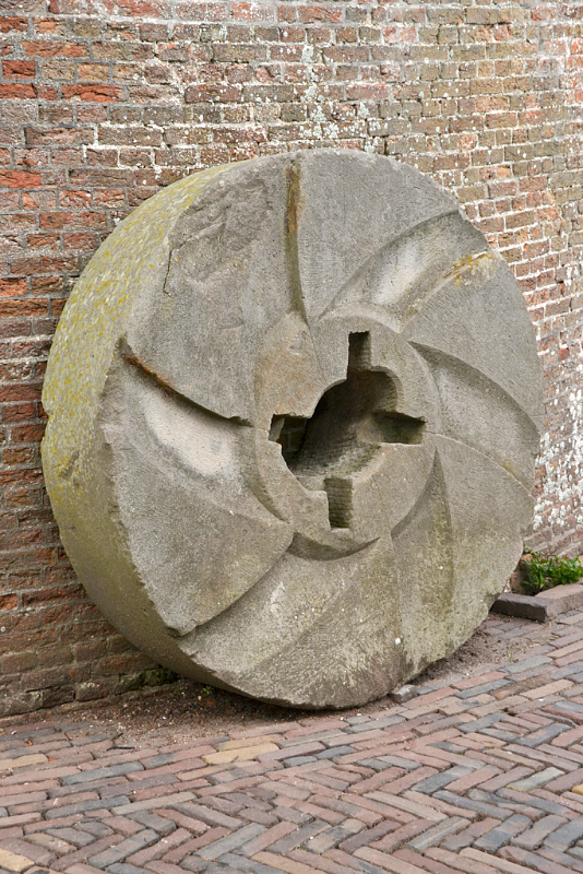 7, Molen 01657 De Koornbloem (Goes), Rob Pols (13-7-2017)Een naast de molen staande oude pelsteen. | Database Nederlandse molens