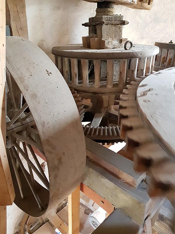 18, Molen 03555 De Lelie (Koudekerke), Pieter Zuijkerbuijk (26-6-2019)Hier is goed het steenrondsel te zien (met de haakse overbrenging) die bijgezet kan worden op het spoorwiel, om zo via een vrijloop van het bovenwiel elektrisch te kunnen malen met alle aanwezige componenten.  | Database Nederlandse molens