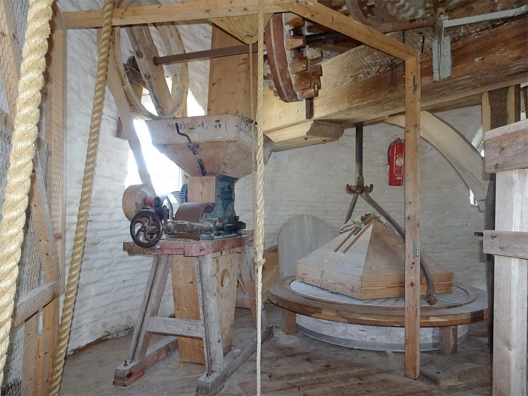 10, Molen 01670 (Naamloos) (Nieuwvliet), Jan de Witte (7-8-2019)De pletter wordt via het spoorwiel aangedreven, hiertoe schuift men het rondsel op de horizontale as naar rechts tot in de spoorwiel kammen. | Database Nederlandse molens