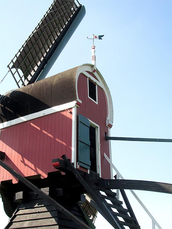 7, Molen 01798 De Kager (Kaag), Piet Glasbergen (8-9-2016)Achterkant kap. In het vaantje zit een plasticglazen zeilscheepje, waar de zon doorheen kan schijnen.  Jan Verhaar is voormalig wedstrijdzeiler. De prachtige houten boot bij de molen is van hem. | Database Nederlandse molens