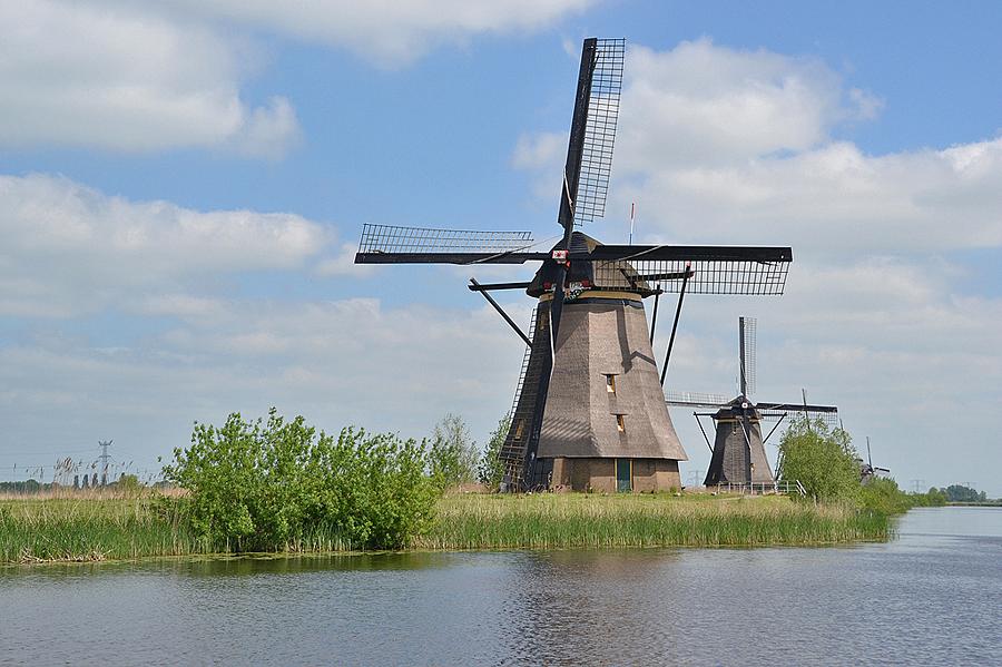 1, Molen 01504 Overwaard Molen No.4 (Kinderdijk), Molen No. 4 met daarachter No. 5 en de wiektoppen van de Overwaardmolens 6, 7 en 8. De foto is gemaakt vanaf het nieuwe wandelpad, dat tegenover de molens No. 1 tot en met 3 ligt.  Rob Pols (15-5-2015). | Database Nederlandse molens