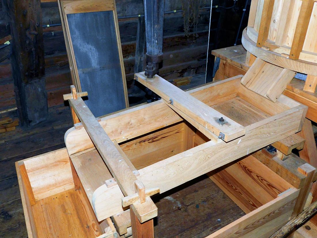 22, Molen 01760 De Lelie (Rotterdam), Piet Glasbergen (27-6-2018)Schudzeef. Het onderste deel van de zeefas is een krukasje, dat de draai omzet in heen-en-weer. | Database Nederlandse molens