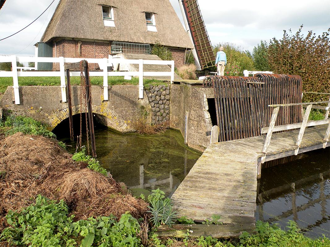5, Molen 02564 Wingerdse Molen (Bleskensgraaf), Jesse Bergquist (5-10-2019)Links de waterloop voor het scheprad, rechts voor de vijzel. | Database Nederlandse molens