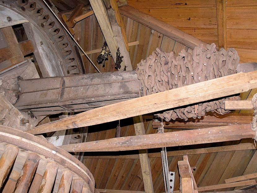 35, Molen 01886 De Eendracht (Dirksland), Willem Jans (9-7-2005)Omdat de bovenas zo vlak ligt, hangt er een flink gewicht aan kettingen aan de achterkant van de as | Database Nederlandse molens