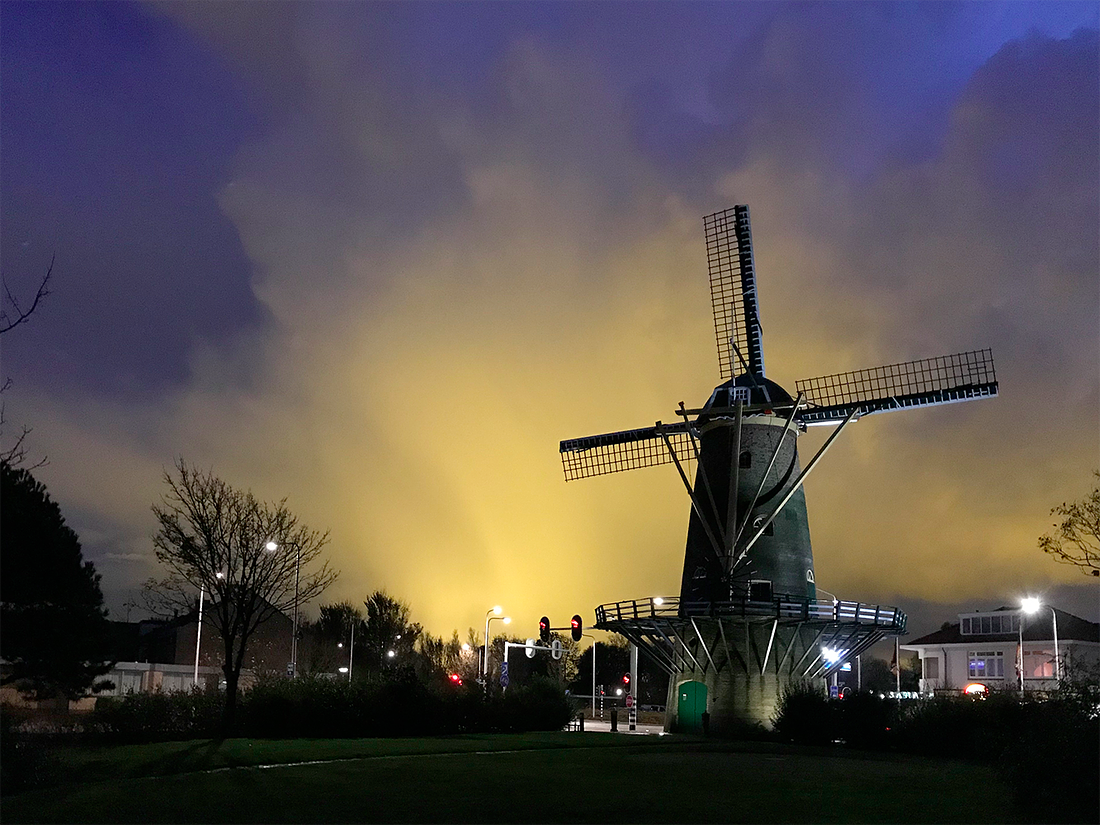 3, Molen 01527 De Vier Winden (Monster), Toby de Kok (5-11-2017)De molen midden in een felle bui. Het licht is afkomstig van het kassengebied.  | Database Nederlandse molens