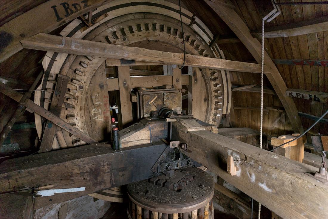 10, Molen 01898 De Zwaan (Ouddorp), Marcel van Nies (16-3-2019)Bemerk de 6 witte kammen rechts in het bovenwiel; deze kunnen -evt. met een 7e kam- worden uitgenomen. Met de betreffende wiek beneden, kan de koningsspil vrij draaien, om zo de elektroaandrijving via het spoorwiel mogelijk te maken. | Database Nederlandse molens