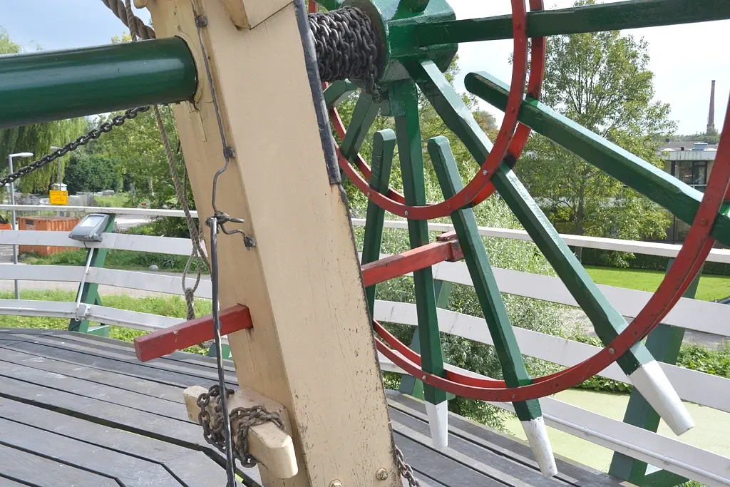 7, Molen 10336 De Speelman (Rotterdam), Rob Pols (10-9-2014)Opvallend is deze houten pal in het kruirad in plaats van het spaakkettinkje. Dit komt bij mijn weten (R.P.) niet bij andere molens in de omgeving voor. | Database Nederlandse molens