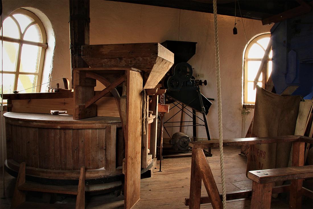21, Molen 01979 De Lelie (Puttershoek),  Jesse in 't Veld (18-1-2019)De steenzolder met het koppel maalstenen, de graanpletter en de graanschoner. | Database Nederlandse molens