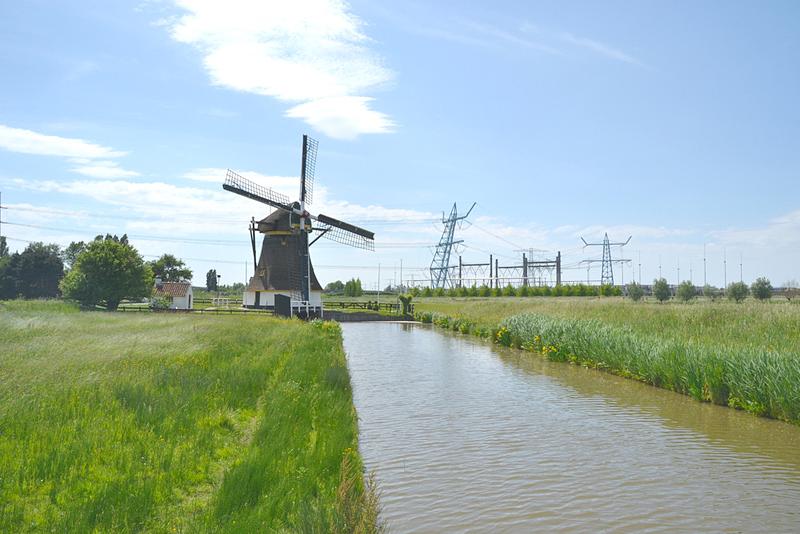 3, Molen 12343 Schaapweimolen (Rijswijk), Rob Pols (21-5-2018)De molen met op de achtergrond het in de tekst genoemde elektriciteitsstation. | Database Nederlandse molens