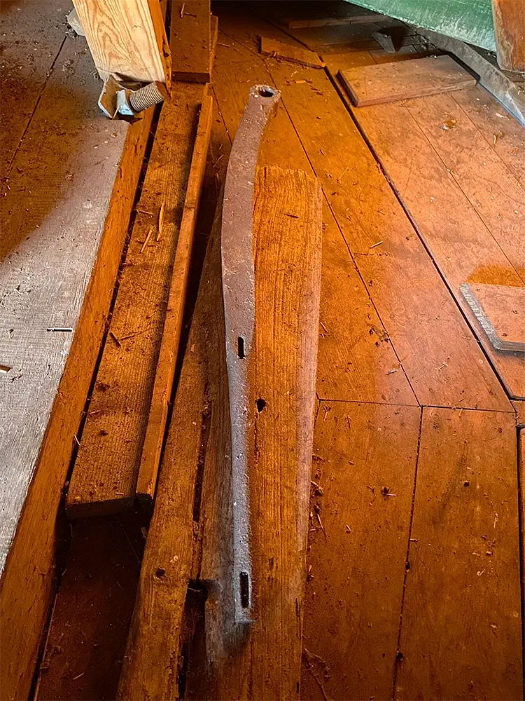 15, Molen 00991 De Herder (Leiden), Bjorn Jannink (18-3-2022)Een hangboom, het stuk ijzer waarmee de stammen op de slee van een zaagmolen geklemd worden, is na de verbouwing tot huidige zaagmolen omgebouwd tot koebout van de vang en word sinds de restauratie van 1994/2001 los in de molen bewaard | Database Nederlandse molens