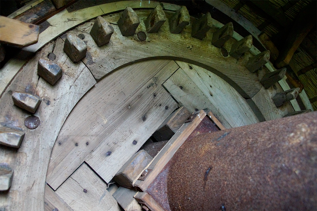 13, Molen 01805 De Kok (Warmond), Matthieu Hoogduin (20-5-2017)Foto van het bovenwiel en een deel van de as. Goed te zien is dat de molen geen gegoten as heeft maar een constructie as. Deze is veel lichter en daarom is de as van achteren verzwaard met lood (niet op de foto). | Database Nederlandse molens