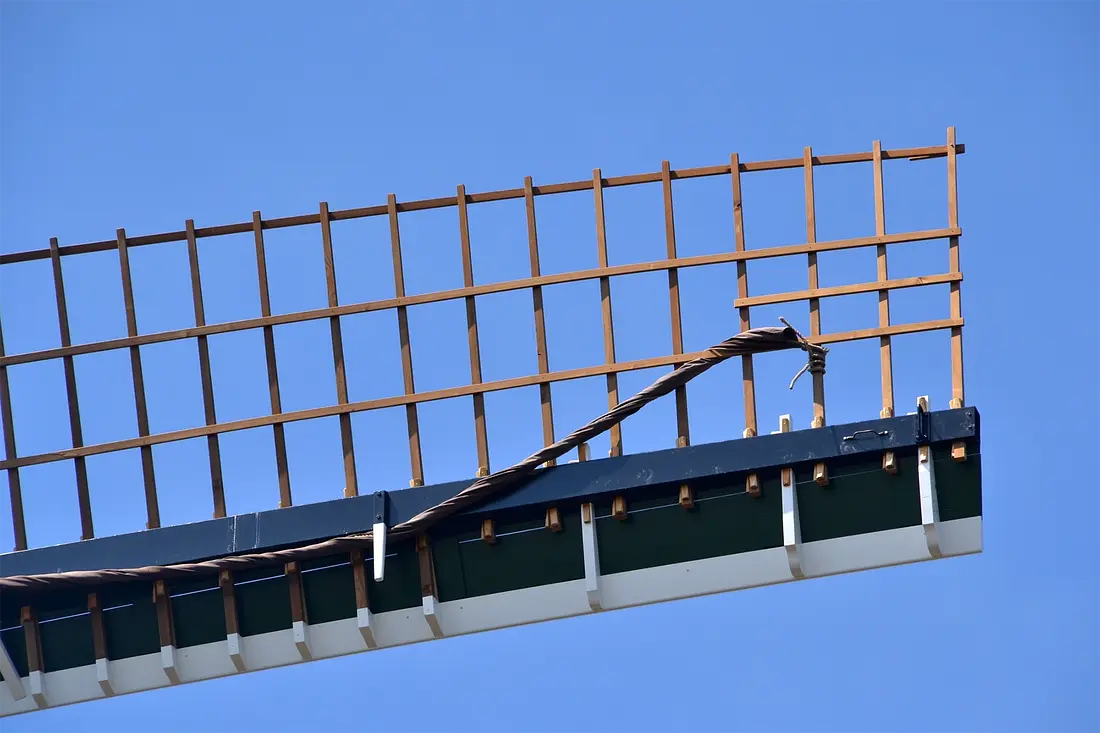 7, Molen 12213 De Palmboom (Schiedam), Rob Pols (28-4-2022)De typische Schiedamse kenmerken in de ophekking van de Oud-Hollandse wiekvorm; te zien zijn drie zogenaamde scheerhouten (de witte houten wiggen) en het verlengde zwichtlatje tussen de twee binnenzoomlatten. Deze langer doorlopende zwichtlatten kwamen van oudsher op de meeste Schiedamse molens voor. Daarbuiten in Nederland niet of nauwelijks, ook niet op molens in de aangrenzende gemeenten. | Database Nederlandse molens