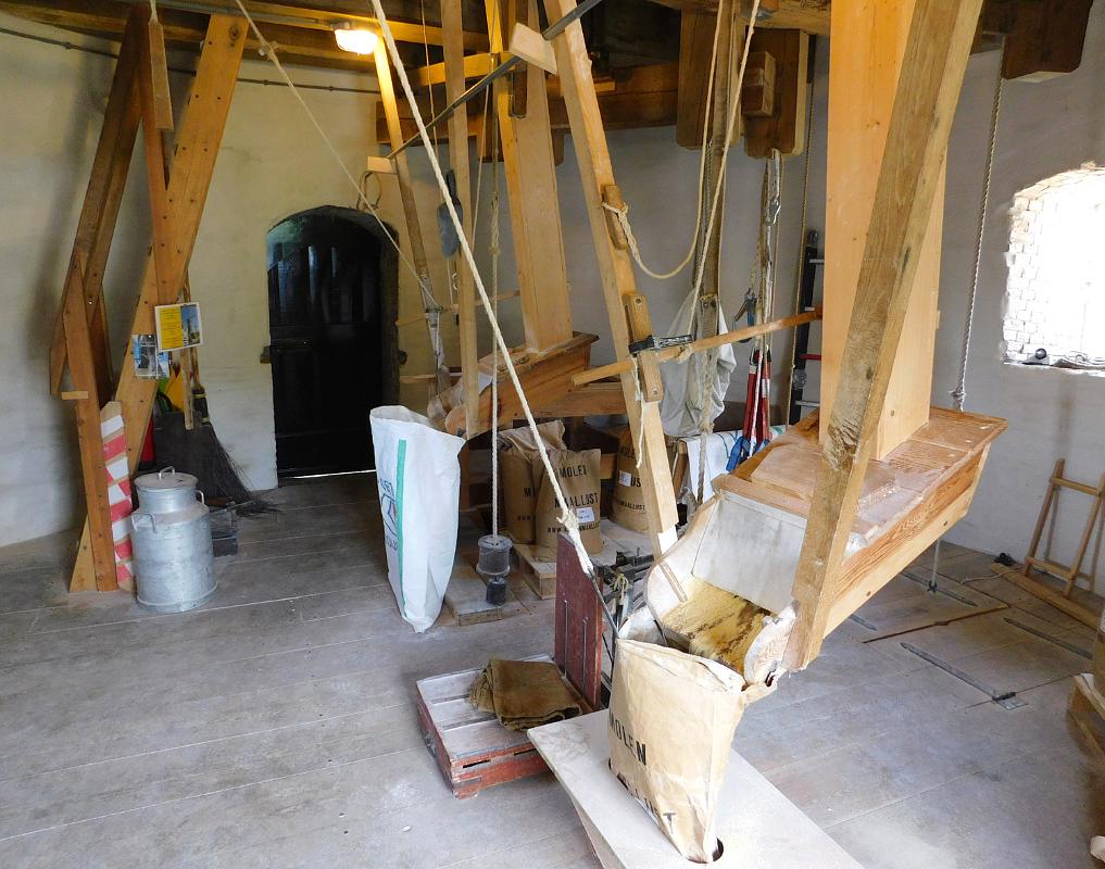 10, Molen 12177 Maallust (Amerongen), Piet Glasbergen (21-7-2018) Interieur belt niveau. Maallust werkt vrij veel, voor zichzelf en in opdracht, soms ook met beide stoelen tegelijk.   Hier met één: mais. Voor een veevoederfabriek uit de buurt, die er koeken van maakt voor de beesten. | Database Nederlandse molens