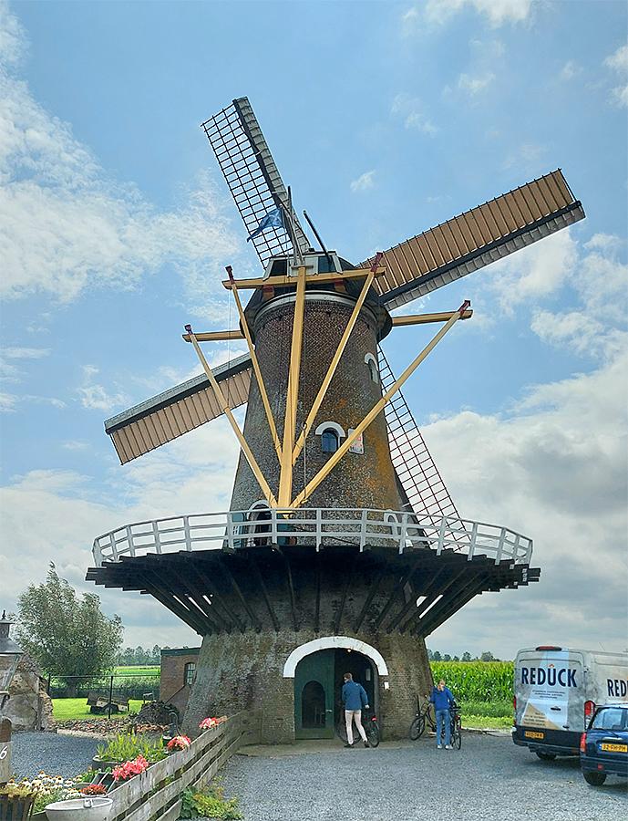 5, Molen 01865 De Oude Molen (Fijnaart), Jesse Bergquist (28-7-2021)De situatie één jaar later: het molenerf van de Oude Molen is drastisch en onherstelbaar veranderd. Als eerste verdween de oude opslagschuur aan de noordoost kant van de molen wegens zware bouwvalligheid. Een paar maanden later verdween het oude bakkerij gebouw wat tegen de molen aan stond aan de zuidwest zijde. Dit laatste gebeurde eigenlijk om dezelfde reden als de andere schuur. Het enige verschil is, dat de stelling deels op het dak van het bakkerijgebouw rustte. Toen een deel van het dak van het bakkerij gebouw naar beneden kwam, is ervoor gekozen om het gebouw, wat ook aan het verzakken was, te slopen en aan deze kant de stelling ook weer van schoren te voorzien.  | Database Nederlandse molens